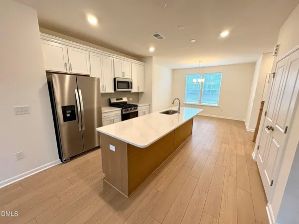 a kitchen with stainless steel appliances a refrigerator a sink a stove a microwave and island