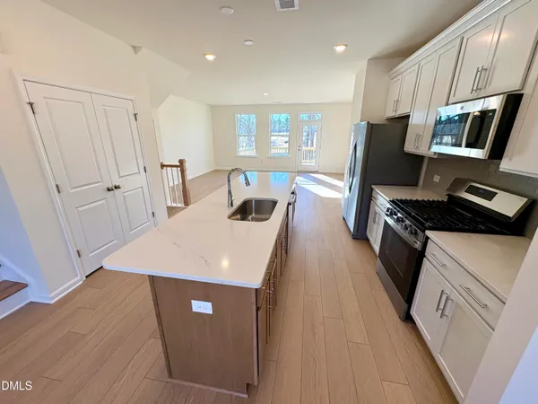 a kitchen with stainless steel appliances a refrigerator sink and stove