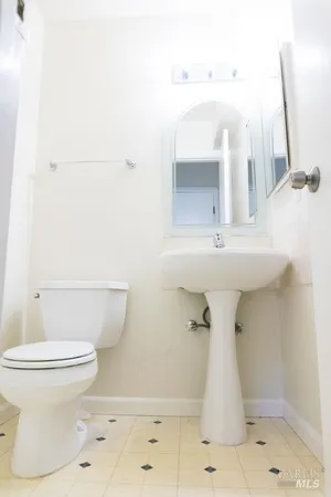 a bathroom with a sink a toilet and a mirror