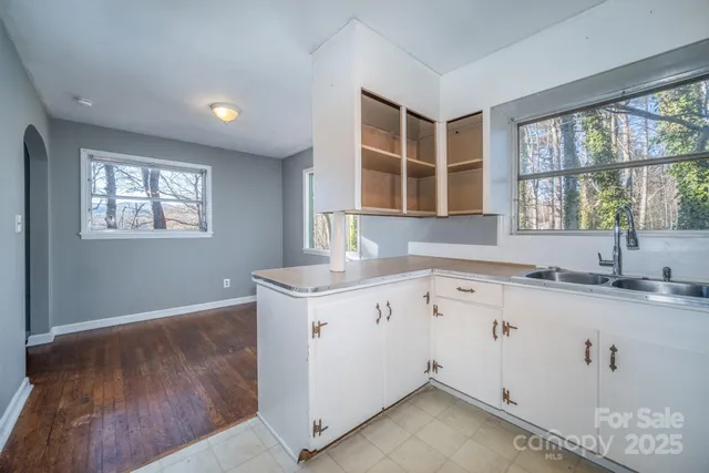 a kitchen with granite countertop a sink window and cabinets