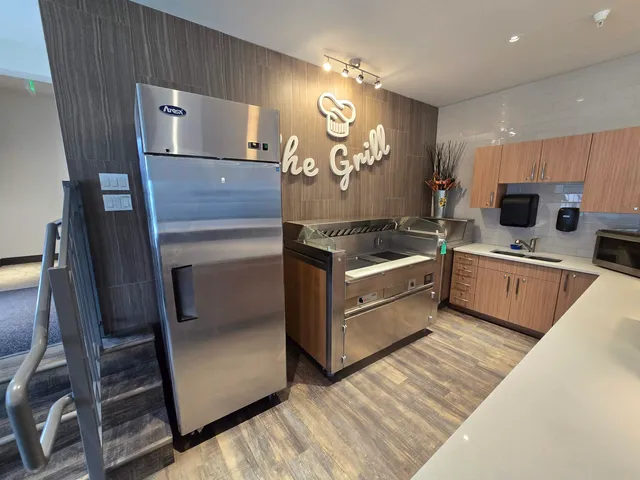 a large kitchen with stainless steel appliances lots of counter space and furniture