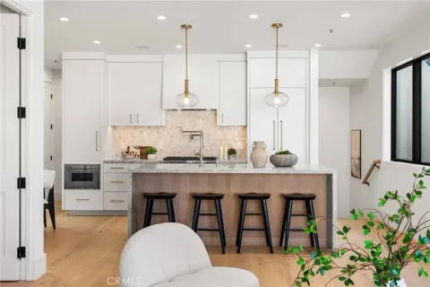 a open kitchen with granite countertop a table and chairs in it