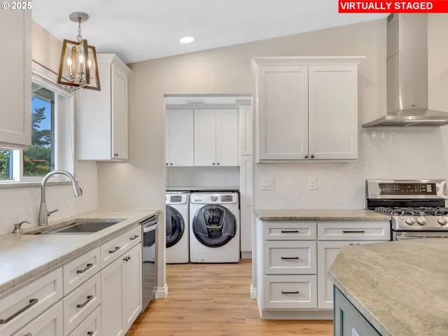 a kitchen with cabinets stainless steel appliances and wooden floor