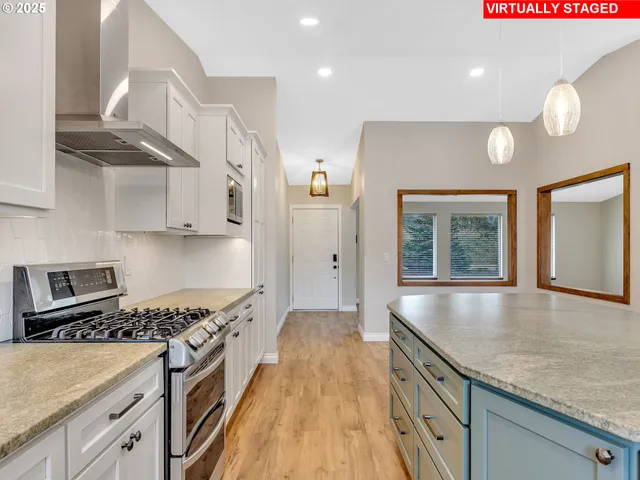 a kitchen with stainless steel appliances granite countertop a sink a stove and a refrigerator