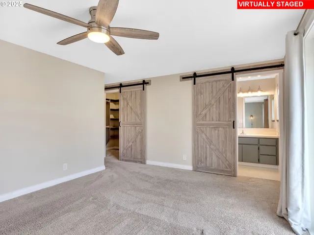 an empty room with closet and a ceiling fan