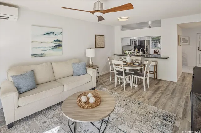 a living room with furniture a rug and kitchen view
