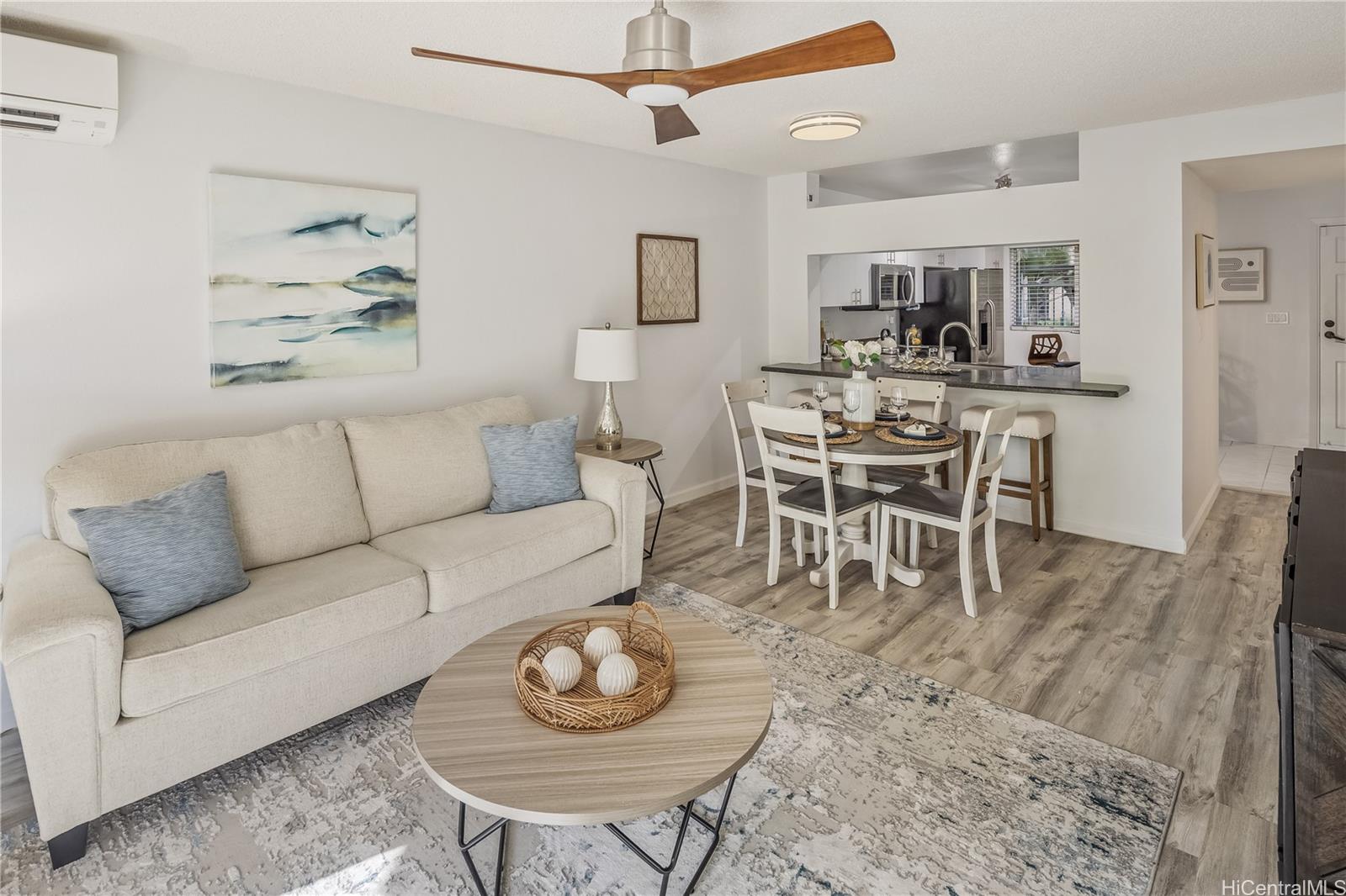 a living room with furniture a rug and kitchen view
