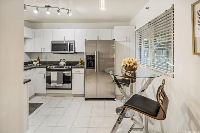 a kitchen with stainless steel appliances granite countertop a stove refrigerator sink and microwave