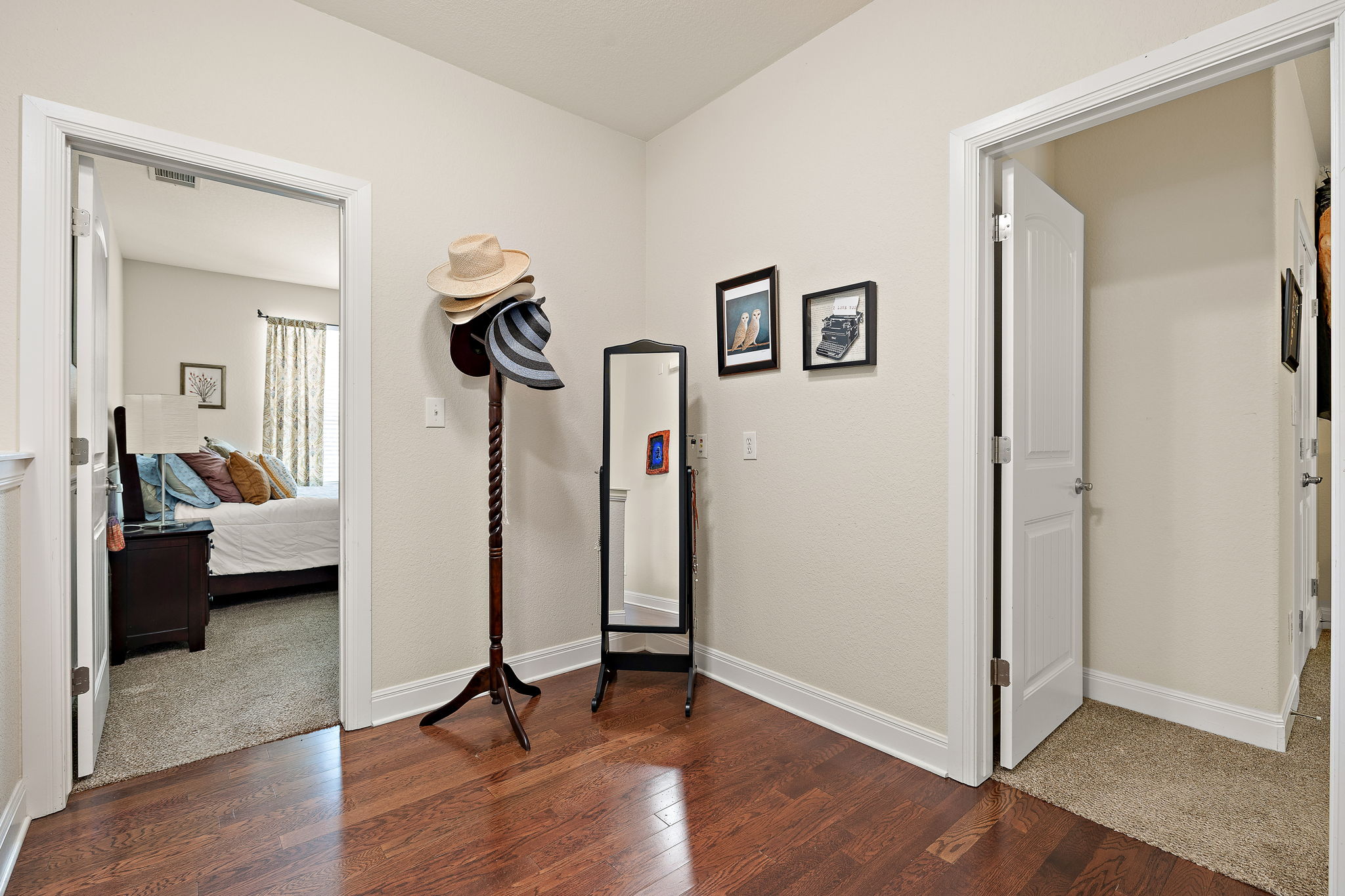 6708 Menchaca Road, Unit 10 Austin, TX 78745 - Photo 19 of 28 Wood-finish flooring throughout a central hall featuring white baseboards, solid doors, and light neutral wall tones