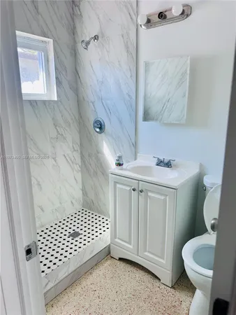 a bathroom with a sink toilet and shower