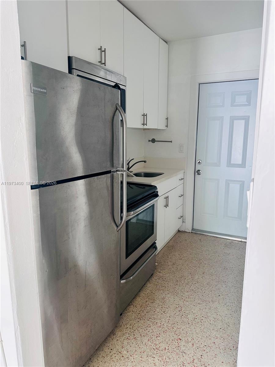 1450 Southwest 6th Street, Unit 2 Miami, FL 33135 - Photo 5 of 12 a kitchen with cabinets and a refrigerator