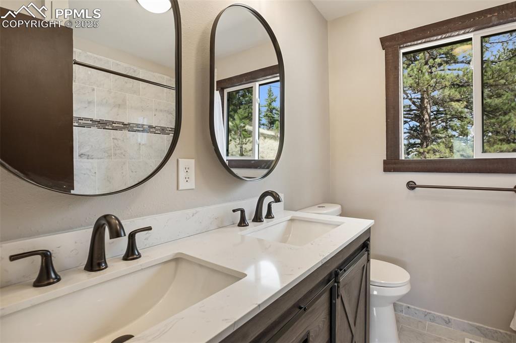 39609 Highway 24 Lake George, CO 80827 - Photo 17 of 46 Main floor master bath with double vanity, toilet, a sink and tile