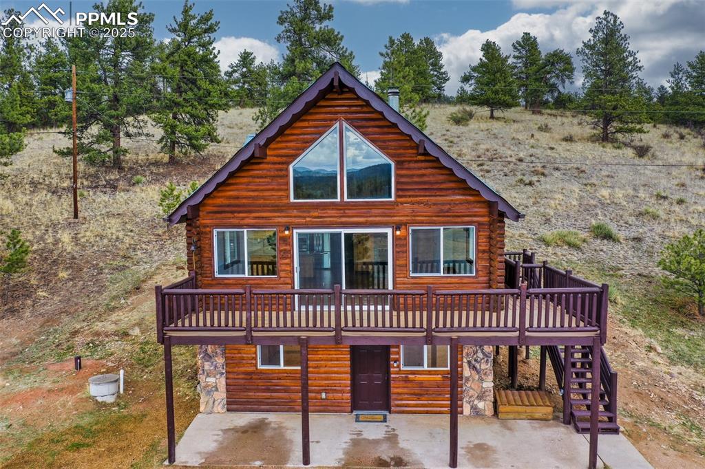 39609 Highway 24 Lake George, CO 80827 - Photo 2 of 46 View of front of house with stairs, a patio area, a deck, and stone siding