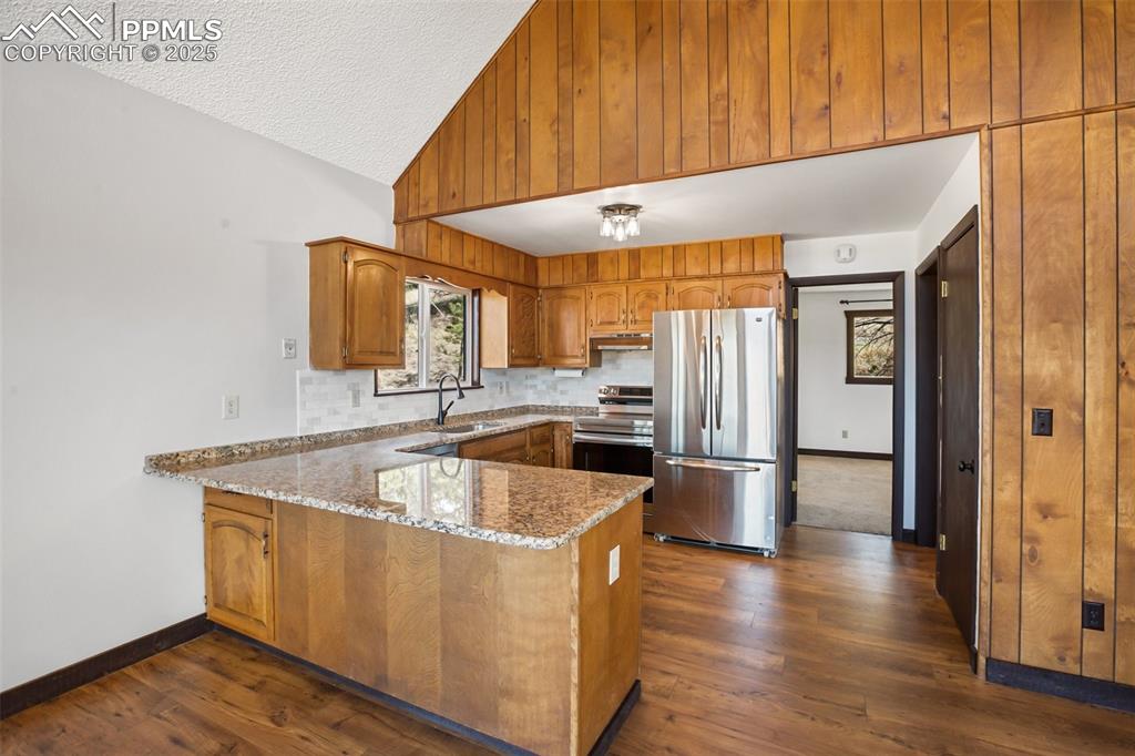 39609 Highway 24 Lake George, CO 80827 - Photo 4 of 46 Kitchen with light stone counters, a sink, brown cabinetry, stainless steel appliances, and a peninsula