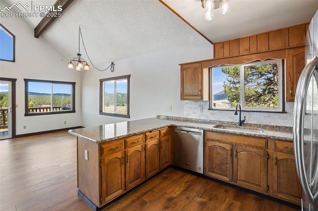 39609 Highway 24 Lake George, CO 80827 - Photo 6 of 46 Kitchen with a sink, appliances with stainless steel finishes, decorative backsplash, and a peninsula