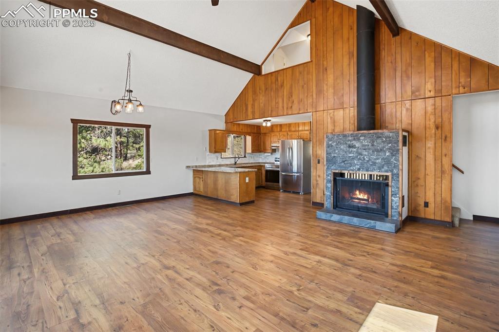 39609 Highway 24 Lake George, CO 80827 - Photo 7 of 46 Unfurnished living room featuring high vaulted ceiling, beamed ceiling, and dark wood-style flooring