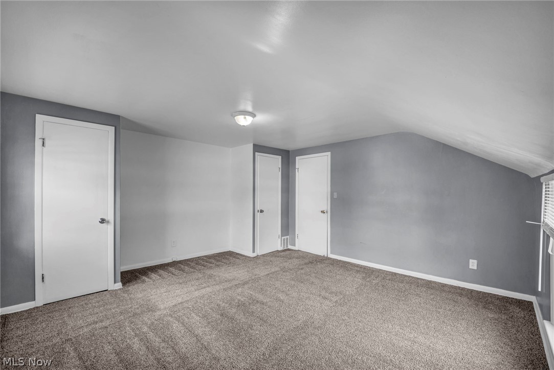 2313 North Taylor Road Cleveland Heights, OH 44112 - Photo 23 of 32 Carpeted room featuring sloped ceilings, multiple doors, and a window with horizontal blinds