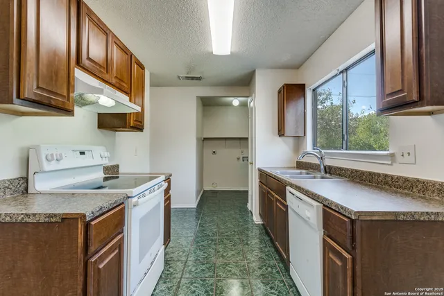 a kitchen with stainless steel appliances granite countertop a sink stove and cabinets