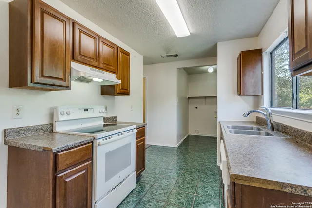 a kitchen with stainless steel appliances granite countertop a sink stove and cabinets