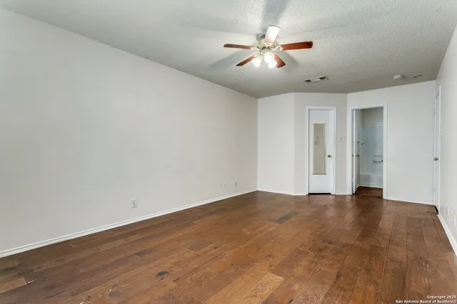 a view of an empty room with wooden floor