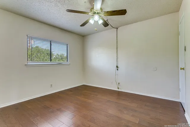 an empty room with a window and a fan