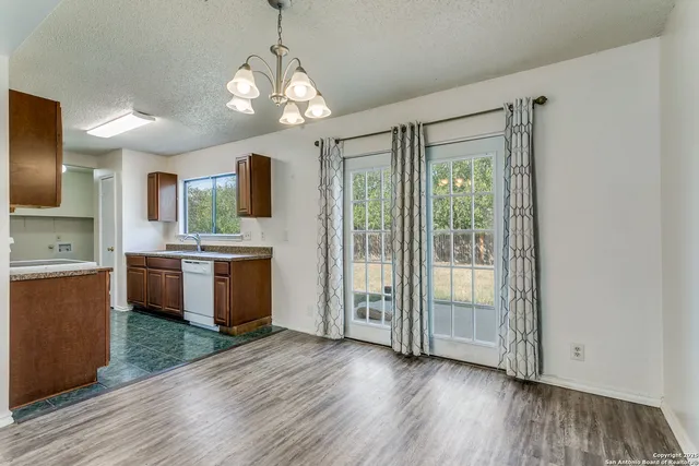 a view of a kitchen with a sink and dishwasher with wooden floor