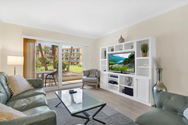 a living room with furniture a flat screen tv and a large window