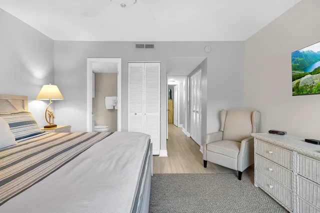 a spacious bedroom with a bed and a lamp