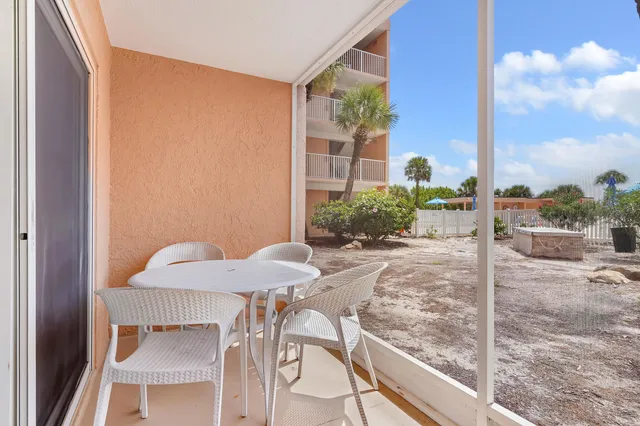 a view of a balcony with table and chairs and potted plants