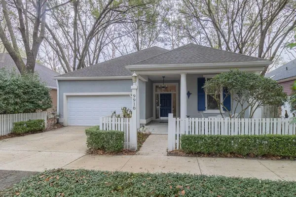 a front view of a house with a garden and plants