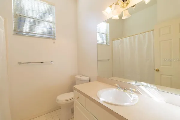 a bathroom with a sink a toilet and mirror