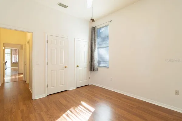 a view of an empty room with wooden floor