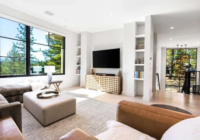 a bedroom with a bed and a flat tv screen next to a window