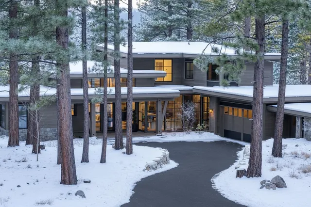 a living room with furniture large windows and fireplace