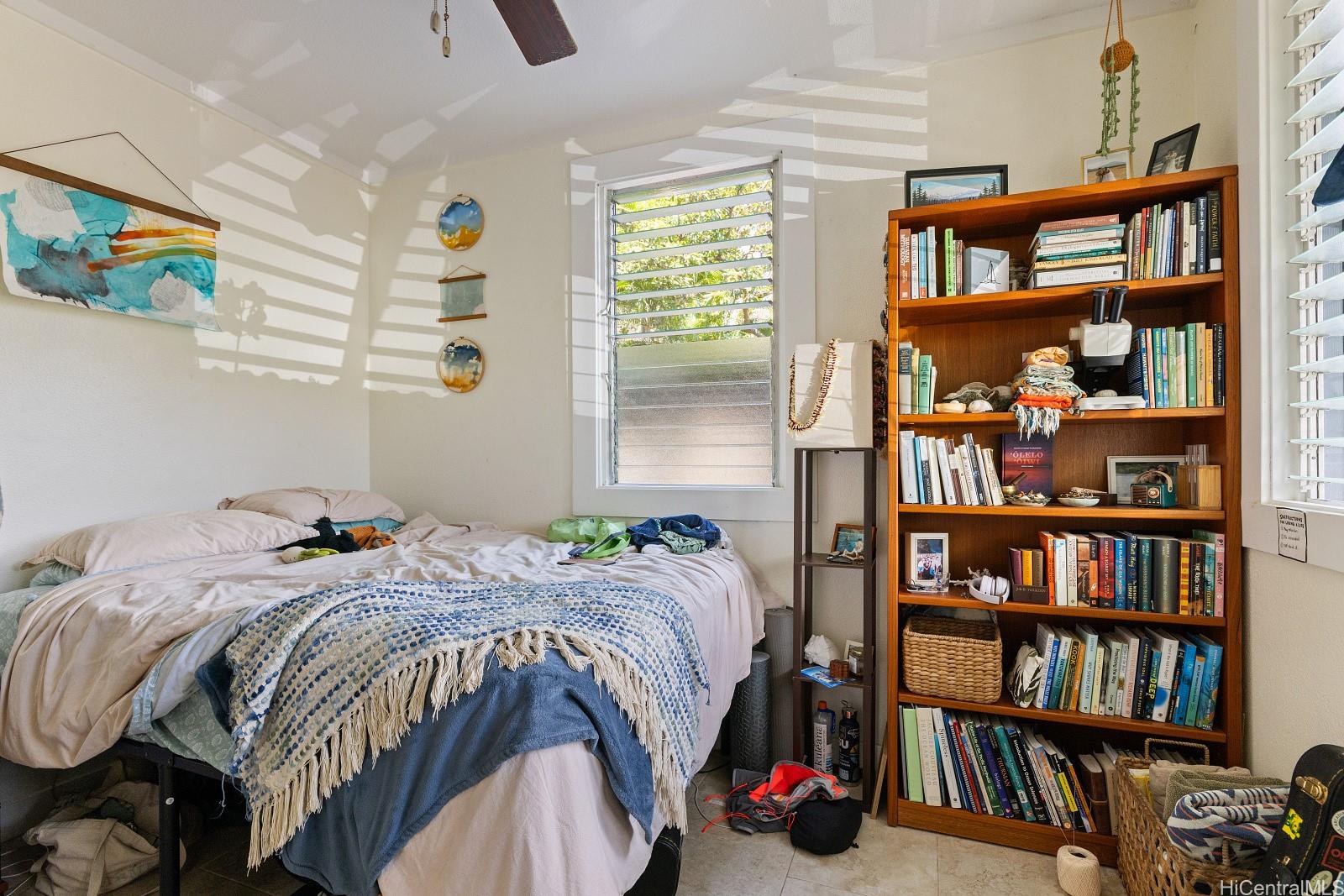2870 Komaia Place, Unit 2870A AND 2884 Honolulu, HI 96822 - Photo 17 of 25 a bedroom with a bed a book shelf and a book shelf