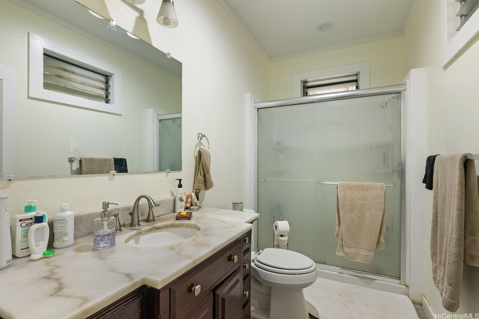 2870 Komaia Place, Unit 2870A AND 2884 Honolulu, HI 96822 - Photo 5 of 25 a bathroom with a granite countertop sink toilet and mirror