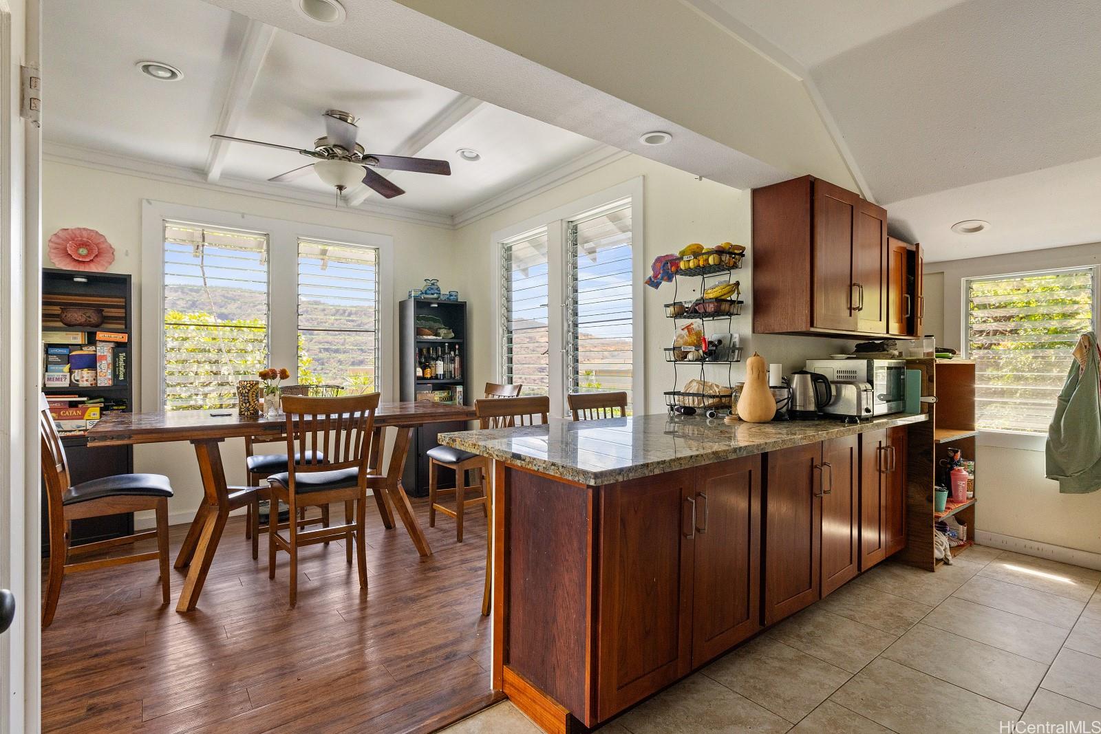 2870 Komaia Place, Unit 2870A AND 2884 Honolulu, HI 96822 - Photo 8 of 25 a kitchen with stainless steel appliances granite countertop a stove top oven a dining table and chairs with wooden floor