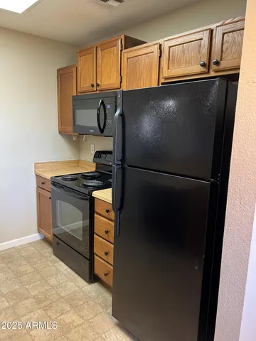 a kitchen with metallic refrigerator and cabinets