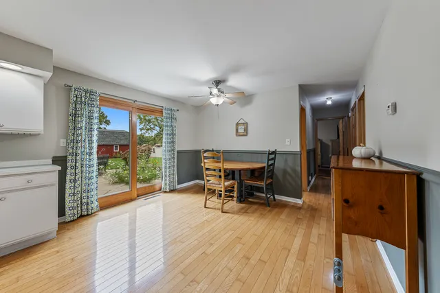 a living room with furniture a floor to ceiling window and wooden floor
