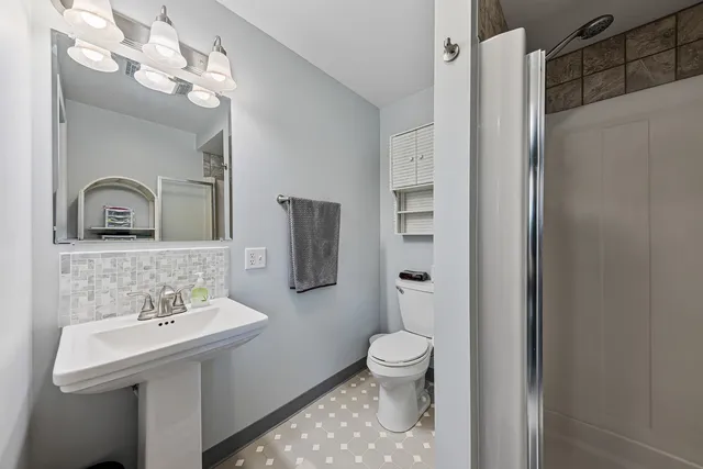 a bathroom with a sink a toilet and shower