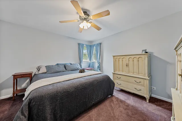 a bedroom with a bed and a ceiling fan