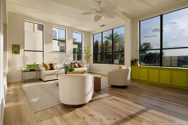 a living room with couches a coffee table and a large window with outer view