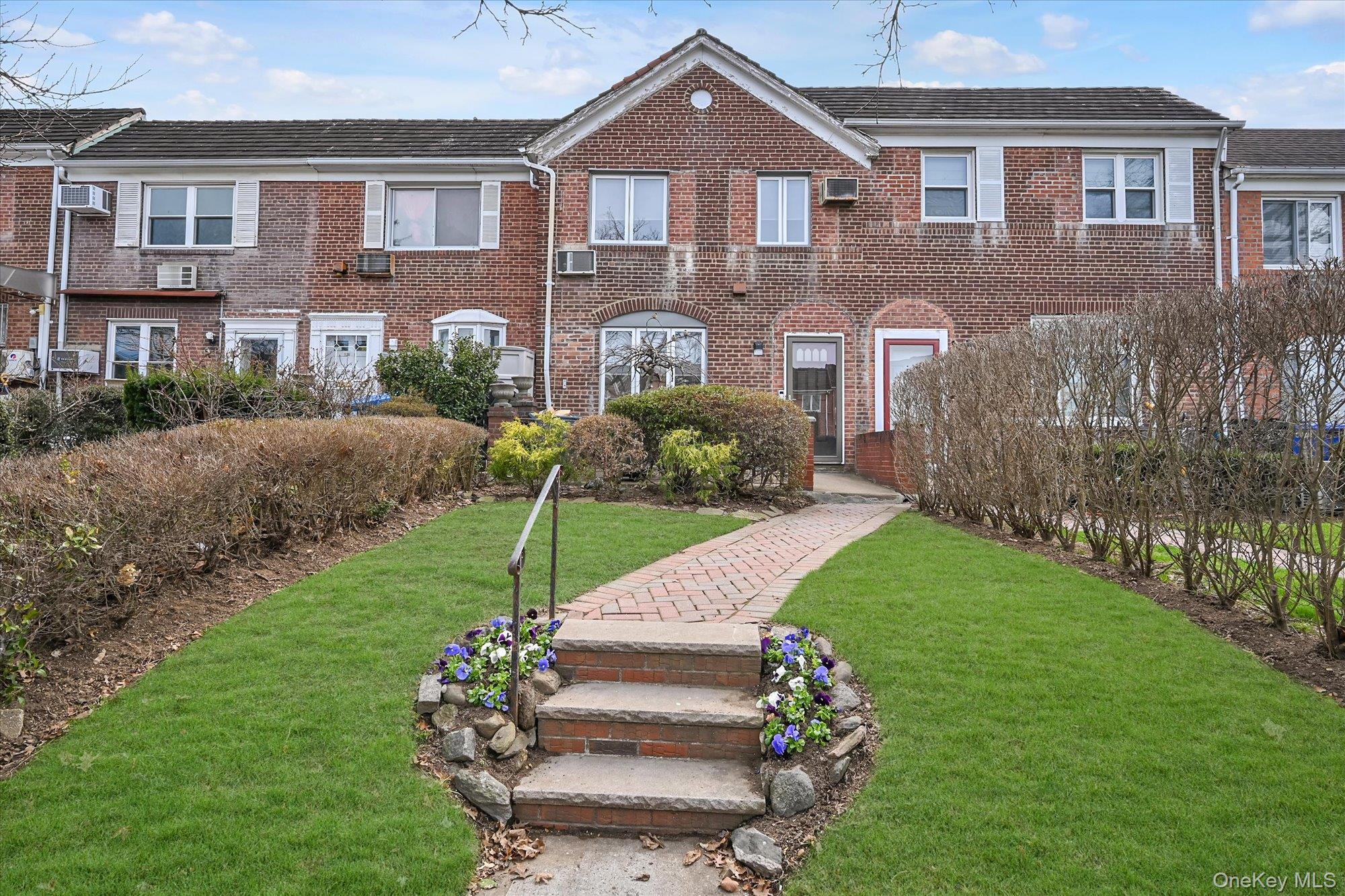 a front view of a house with a garden and pathway