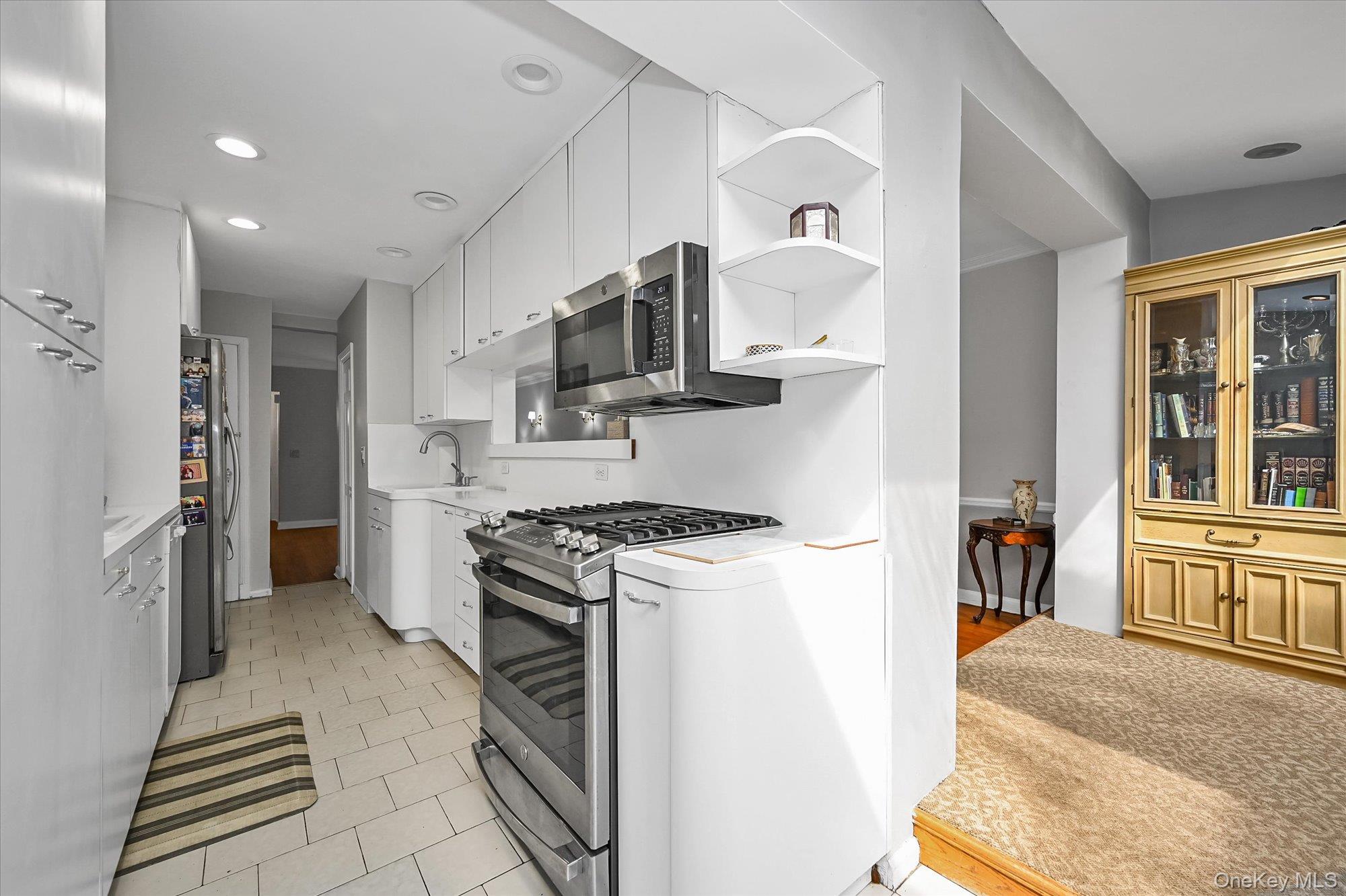 136-54 71st Road Queens, NY 11367 - Photo 12 of 25 a kitchen with stainless steel appliances granite countertop a stove and a refrigerator