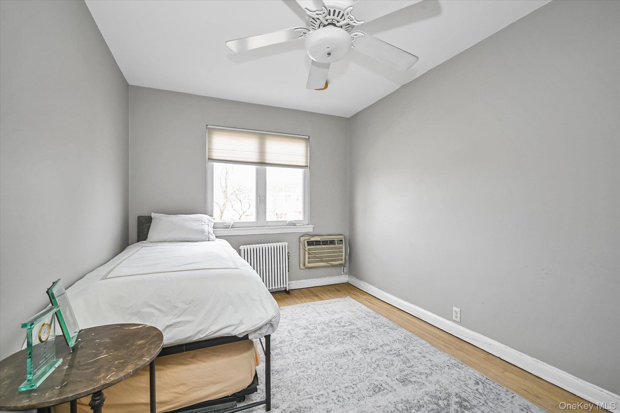 136-54 71st Road Queens, NY 11367 - Photo 20 of 25 a bedroom with a bed and a chair