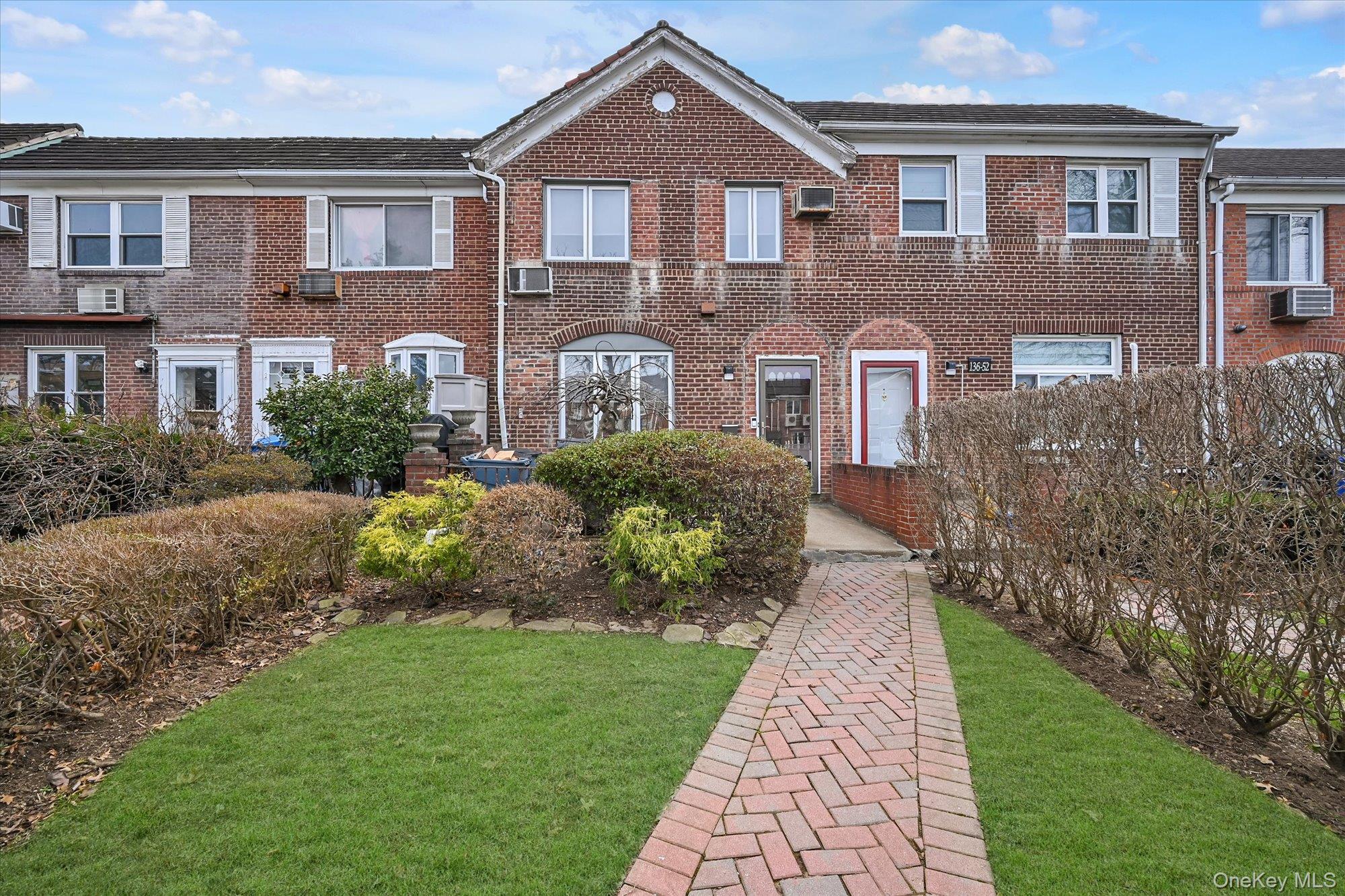 136-54 71st Road Queens, NY 11367 - Photo 2 of 25 a front view of a house with garden