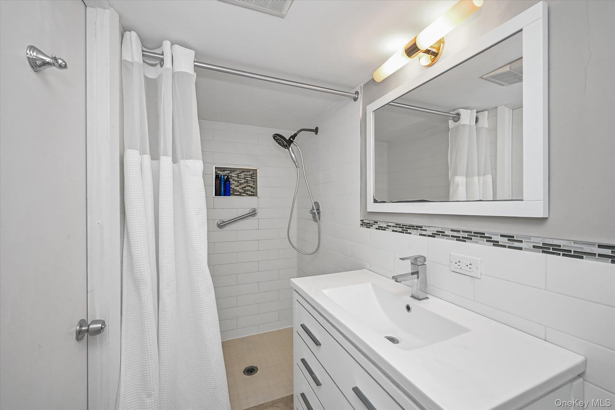 136-54 71st Road Queens, NY 11367 - Photo 22 of 25 a bathroom with a sink vanity granite tub shower and a mirror