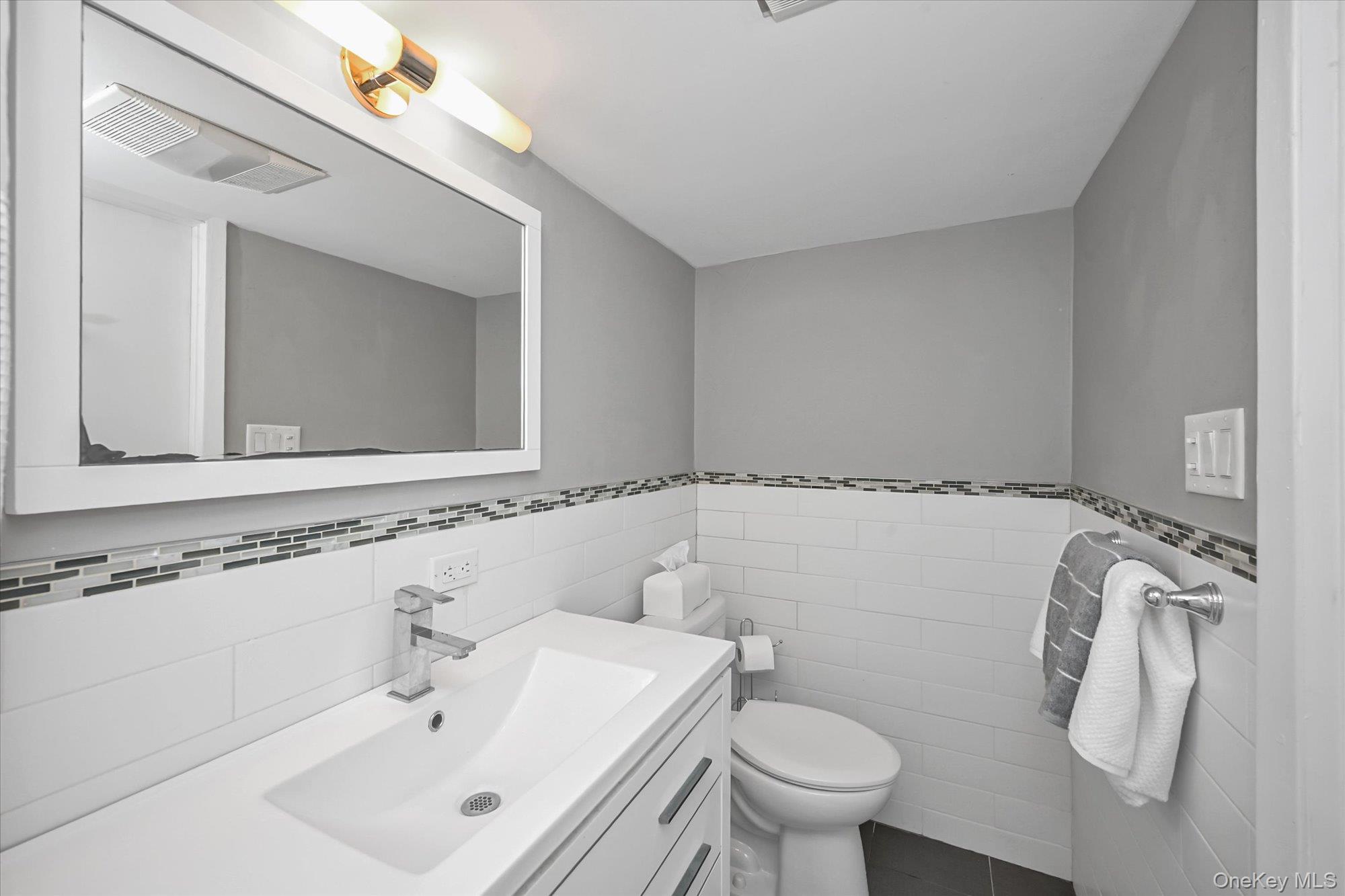 136-54 71st Road Queens, NY 11367 - Photo 23 of 25 a bathroom with a sink vanity mirror and toilet