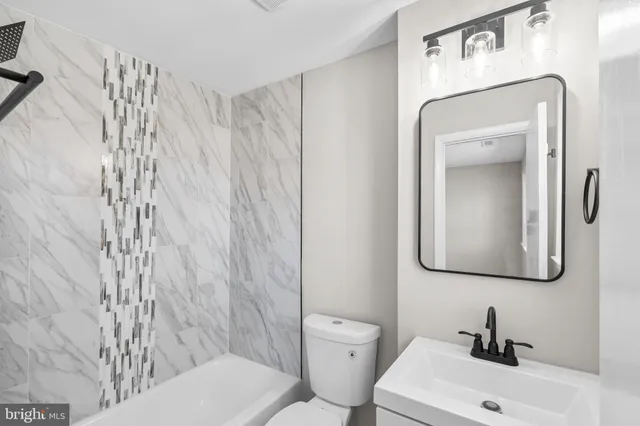 a bathroom with a toilet sink and mirror