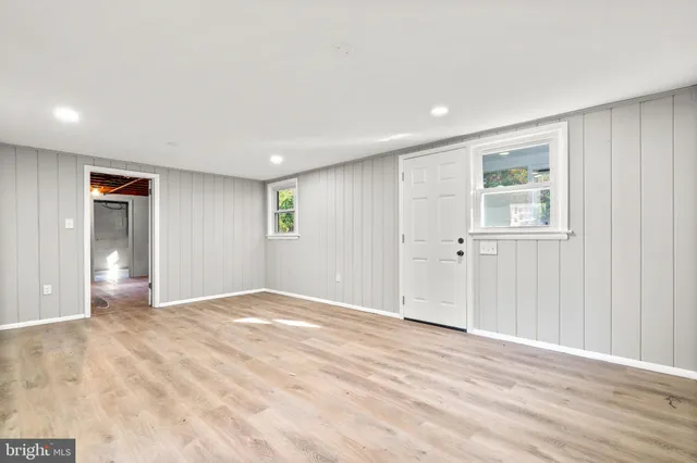 a view of an empty room with wooden floor and closet